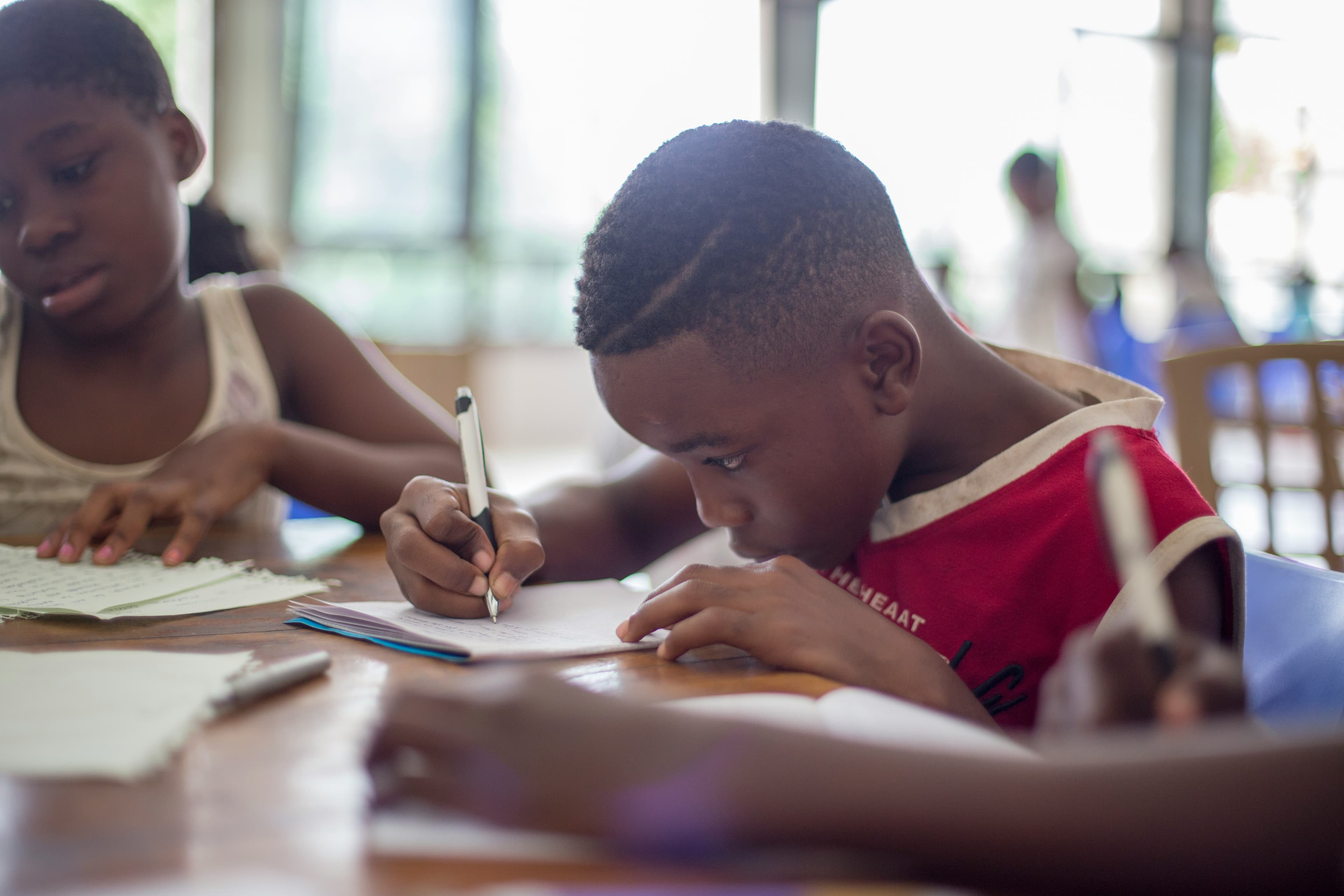 Student focused on writing at a desk